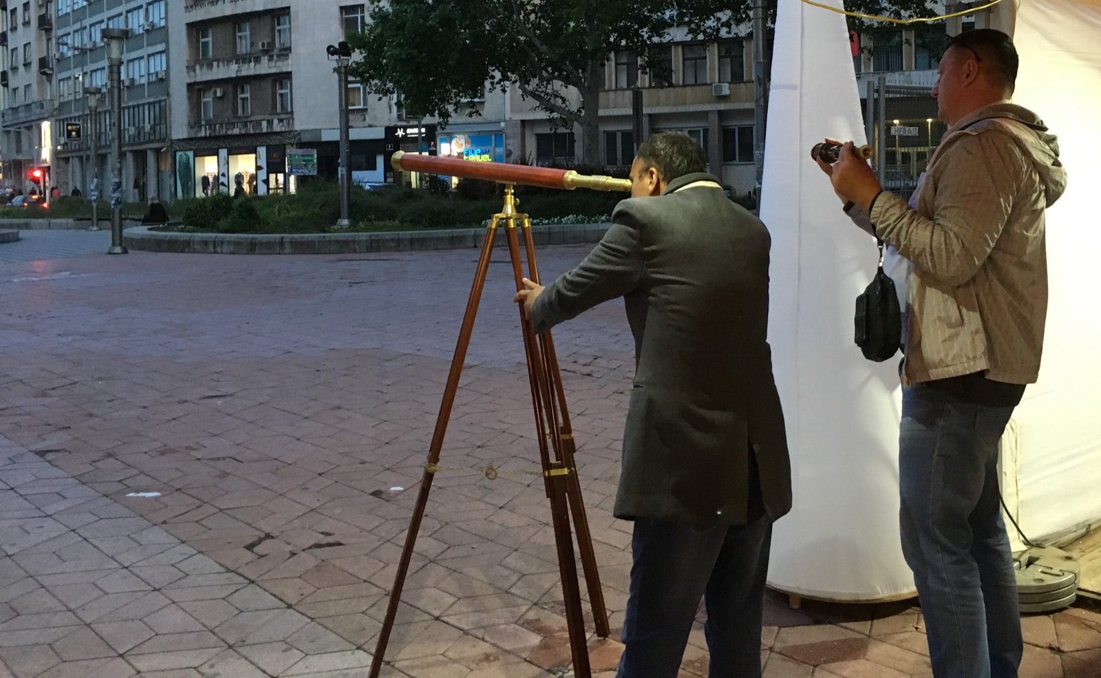 Brass telescope on a wooden tripod at an outdoor display